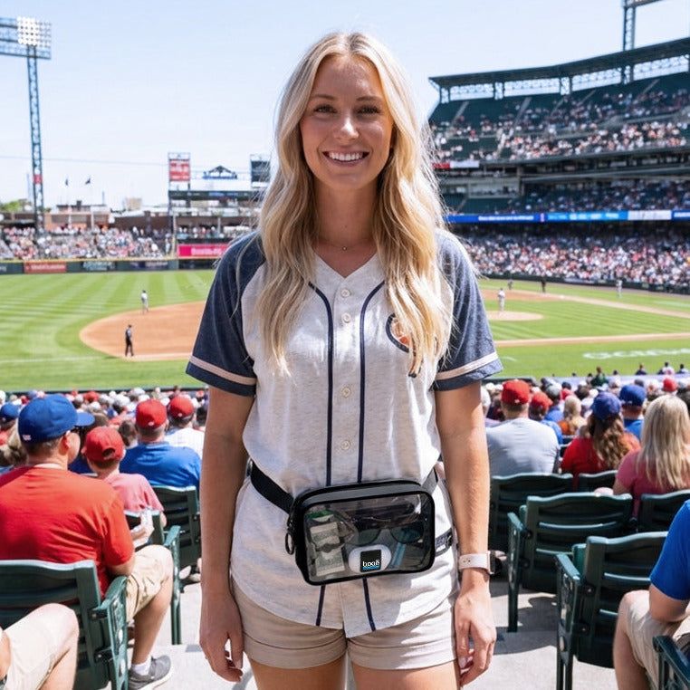 Woman at a baseball game with stadium and crowd in the background